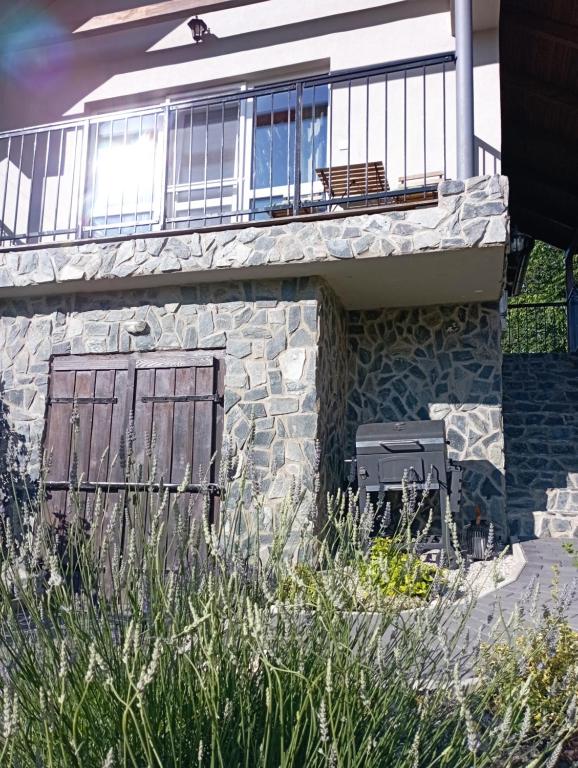 ein Steingebäude mit einem Balkon und einem Fenster in der Unterkunft Vulcanus Apartment in Badacsonytomaj