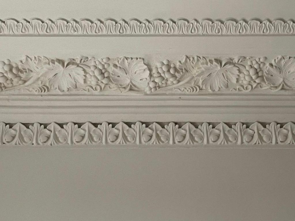 a white wall with a carving of flowers on it at Church Retreat - A Magnificent Seaside Apartment-Award Winning in Hastings