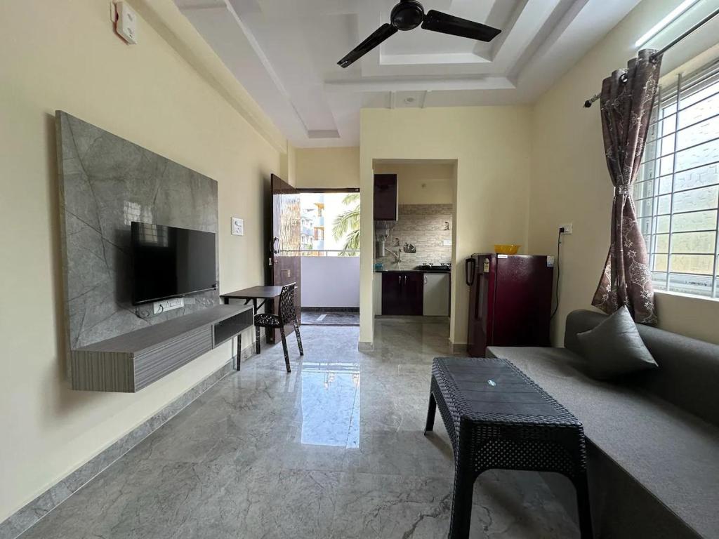 a living room with a couch and a flat screen tv at Cozy Room 1Bhk with Lift 203 in Bengaluru