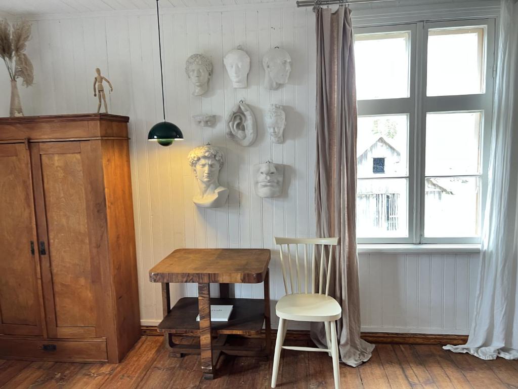 um quarto com uma mesa, uma cadeira e uma janela em Design apartments Jūrmāja em Ainaži