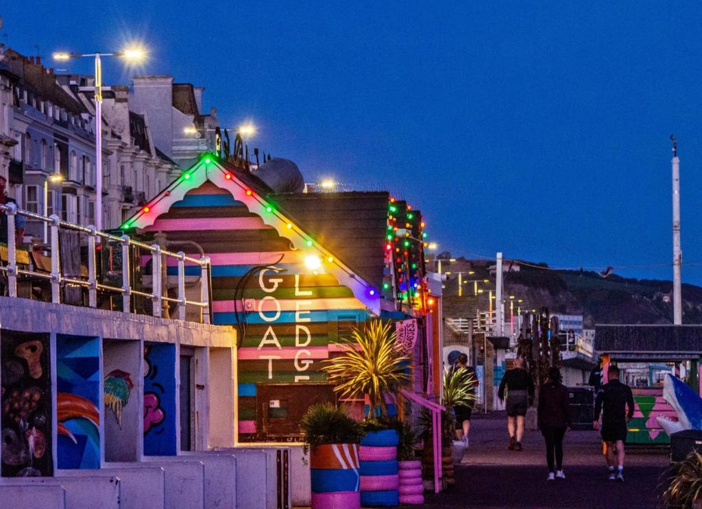 a group of people walking down a street at night at Church Retreat - A Magnificent Seaside Apartment-Award Winning in Hastings