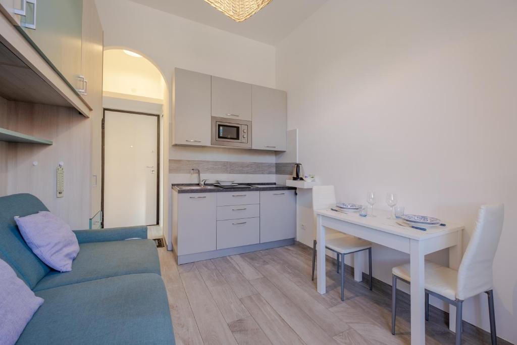 a kitchen and a living room with a couch and a table at Casa Olga in San Bartolomeo al Mare
