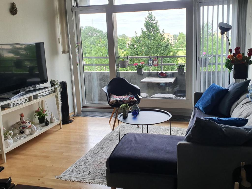 a living room with a couch and a television at Diba beach stay in Kolding