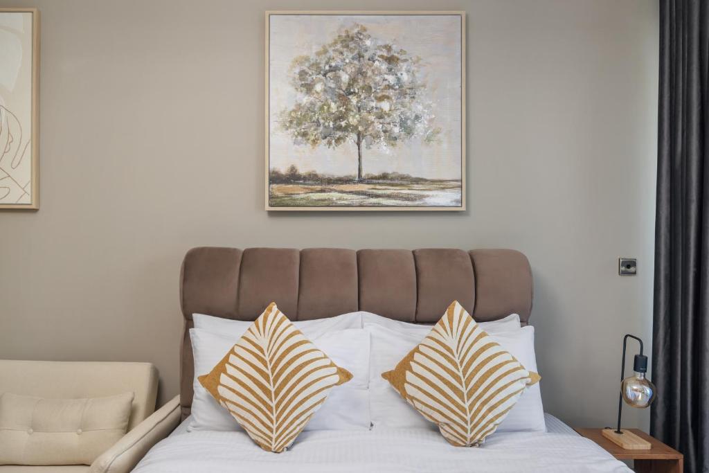 een bed met twee kussens erop en daarboven een foto bij Furnished Studio In Arch Tower, Jlt Near Metro in Dubai