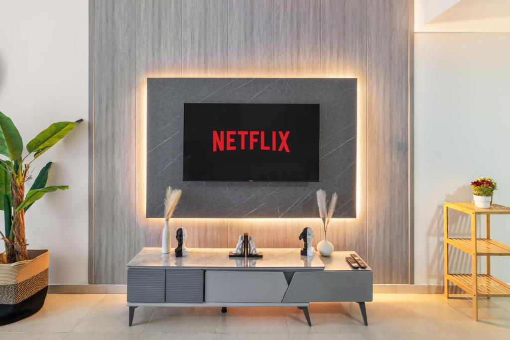 een woonkamer met een netflix-bord aan de muur bij Furnished Studio In Arch Tower, Jlt Near Metro in Dubai