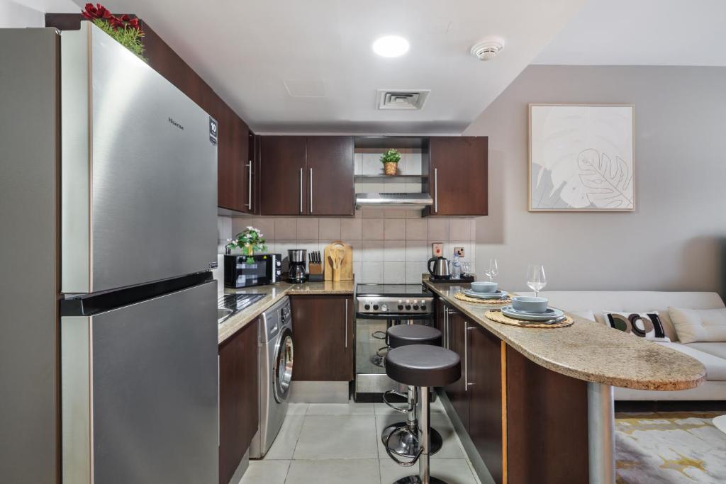 een keuken met een koelkast en een aanrechtblad bij Furnished Studio In Arch Tower, Jlt Near Metro in Dubai