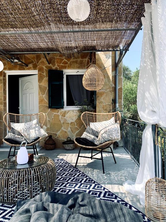 patio con tavolo e sedie in vimini di Villa Aspros - traditionell, ruhig und strandnah a Liapades
