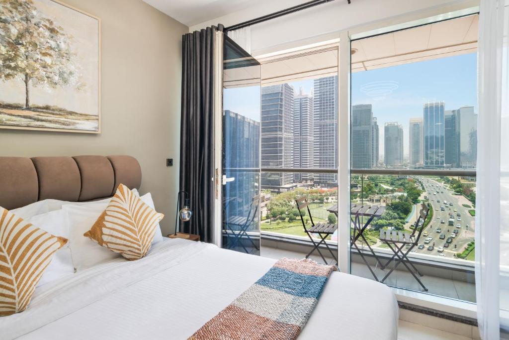 een slaapkamer met een bed en een groot raam bij Furnished Studio In Arch Tower, Jlt Near Metro in Dubai