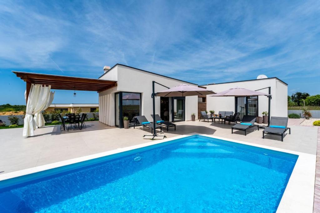 a villa with a swimming pool and a house at Villa Rosa with a heated pool in Privlaka