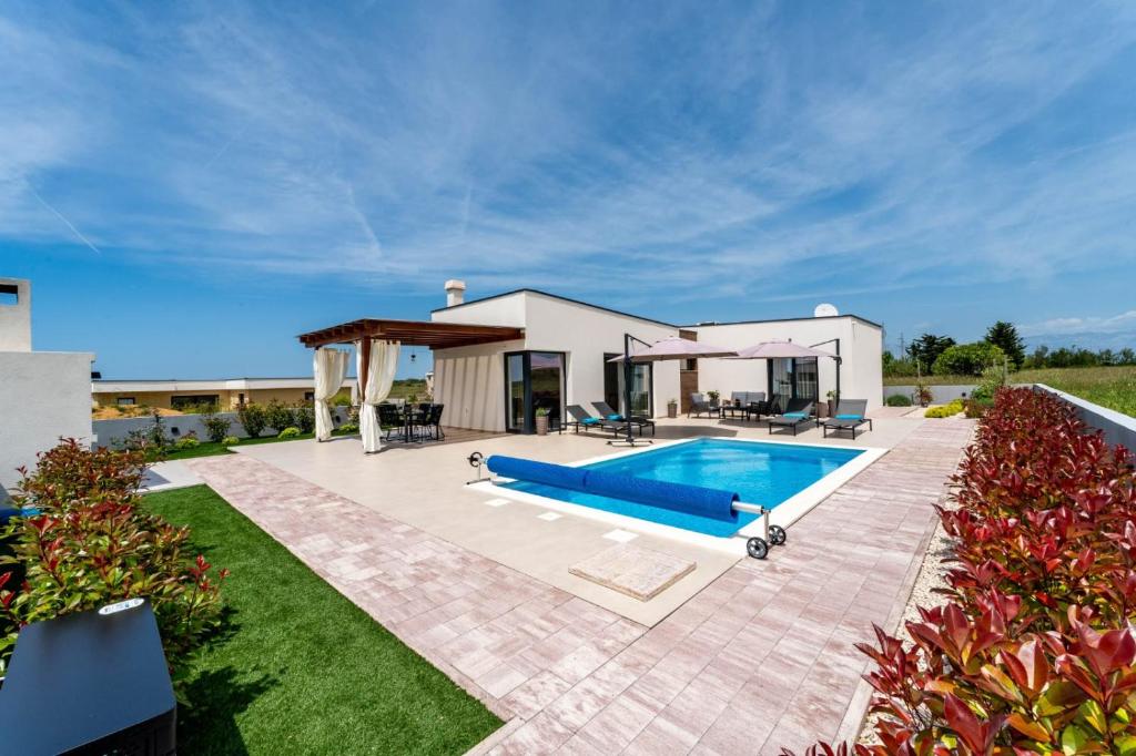 a house with a swimming pool in the yard at Villa Rosa with a heated pool in Privlaka