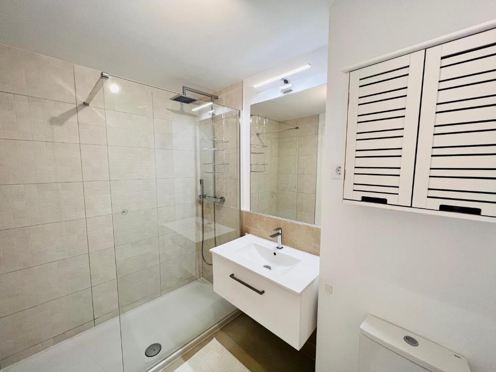 a white bathroom with a sink and a shower at Logement moderne et cosy avec piscine, jacuzzi, salle de sport et billard in Estepona
