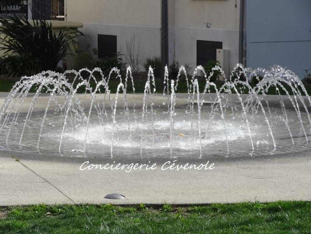 a water fountain in front of a building at Les Bosquets in Alès