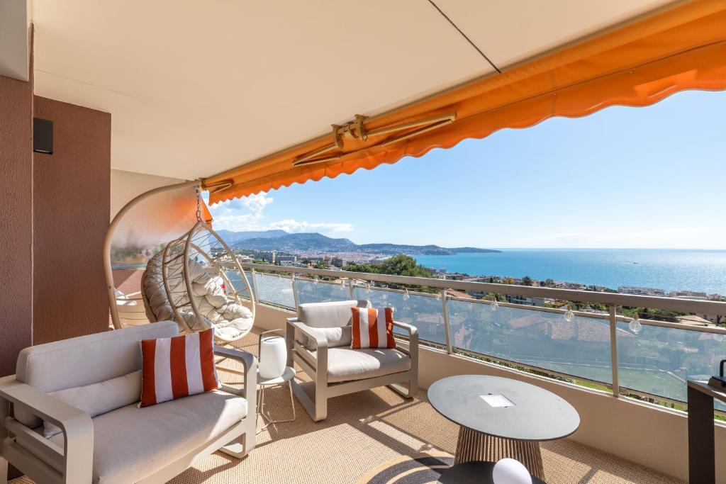 d'un balcon avec des chaises et une vue sur l'océan. dans l'établissement Les Belles Terres - Résidence avec piscine vue mer, à Nice