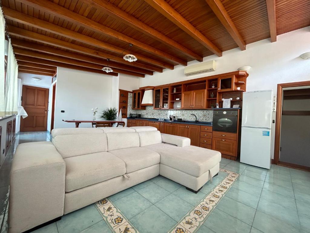 a living room with a white couch and a kitchen at Casa Luna in Lipari