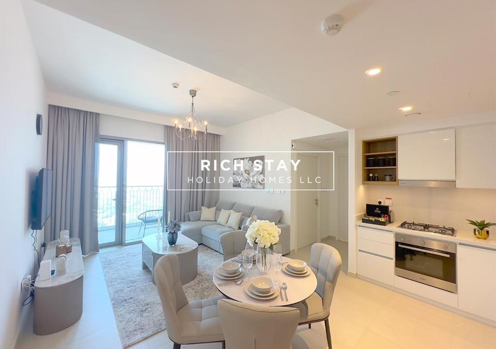 a kitchen and living room with a table and a couch at Incredible 1BR apartment, Downtown Views II by Rich Stay in Dubai