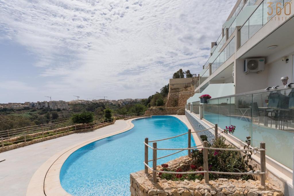 Bazén v ubytování Stunning 3BR home in Gozo with access to pool by 360 Estates nebo v jeho okolí
