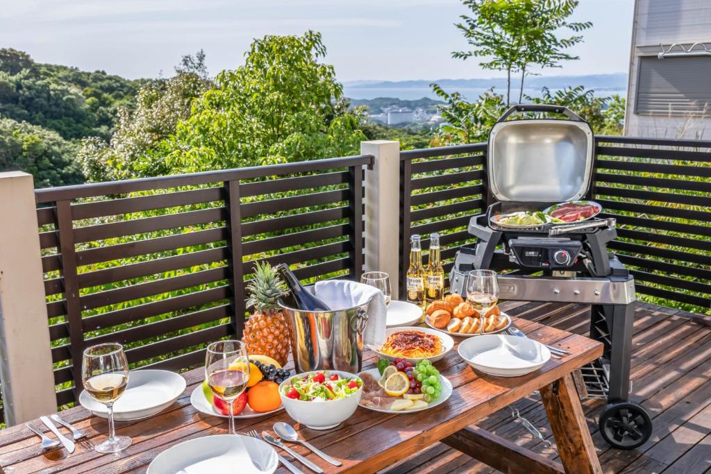 uma mesa com comida e uma grelha num deque em Hopehills em Shirahama