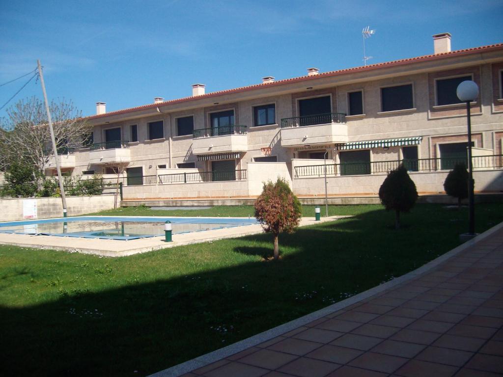 a large building with a yard in front of it at Apartamento en A revolta in Sanxenxo