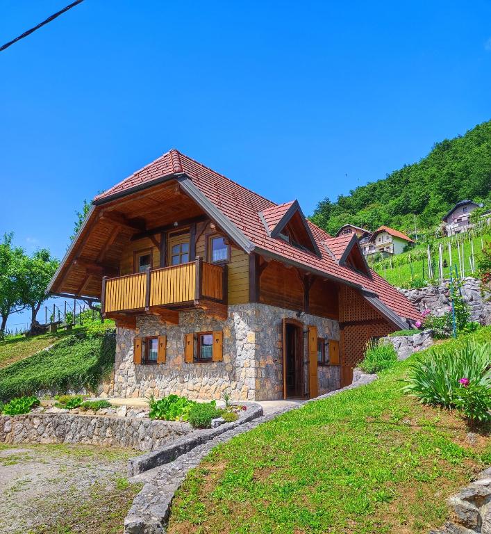 a wooden house with a balcony on a hill at Vineyard cottage Kralj in Uršna Sela