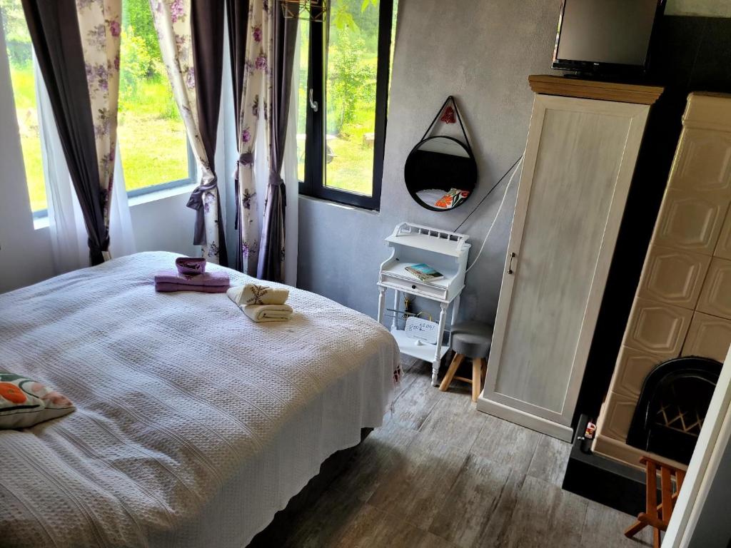 1 dormitorio con cama blanca y ventana en Casa Transylvania en Lupşa