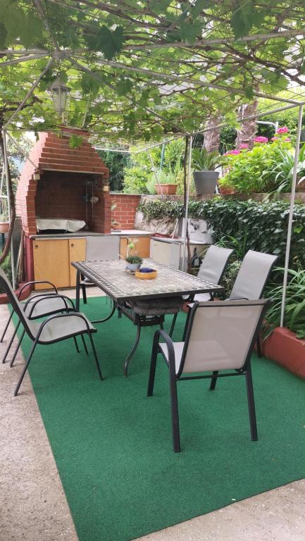 een tafel en stoelen op een patio met groen gras bij Room nono Zlajo in Opatija