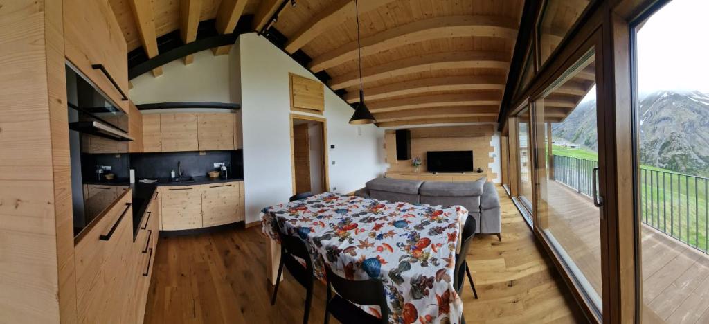 una stanza con tavolo e cucina in una casa di Casa Noemi a Livigno