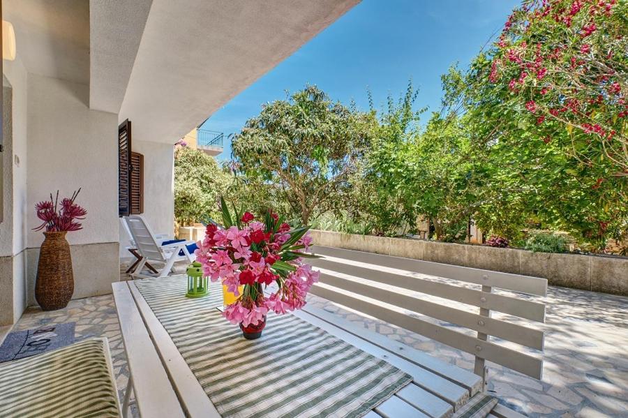 a white bench with a vase of flowers on it at Deja near centar and Čikat bay with private parking in Mali Lošinj
