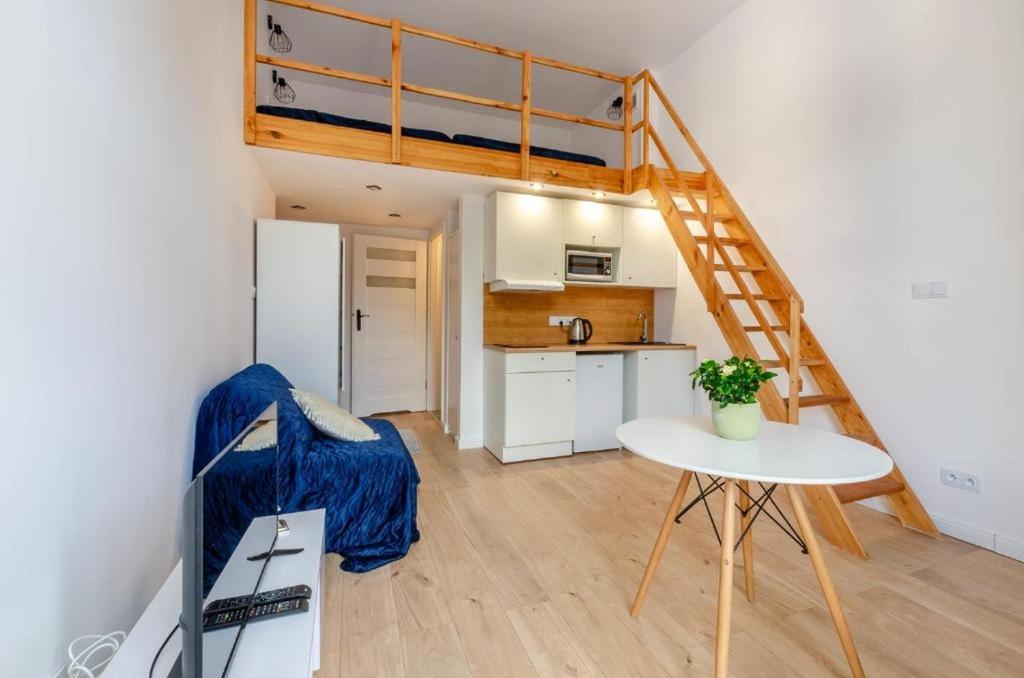 ein kleines Zimmer mit einem Etagenbett und einem Tisch in der Unterkunft Centrum 2 Struga 46 in Łódź