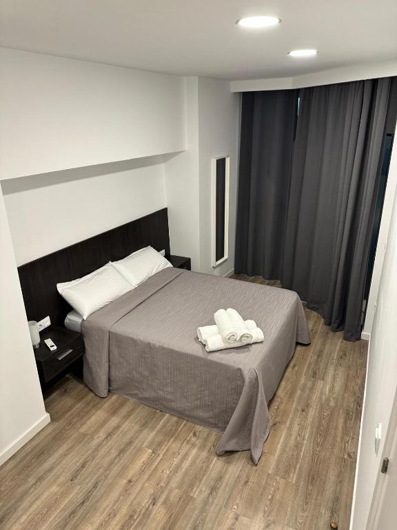 a bedroom with a bed with two towels on it at LOTUS SUITES Alicante in Alicante