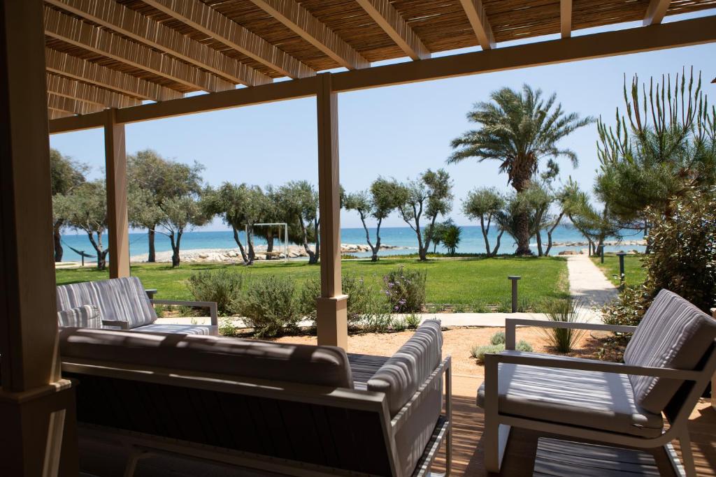 a porch with chairs and a view of the beach at Elya Beach Luxury Suites in Ayios Theodhoros