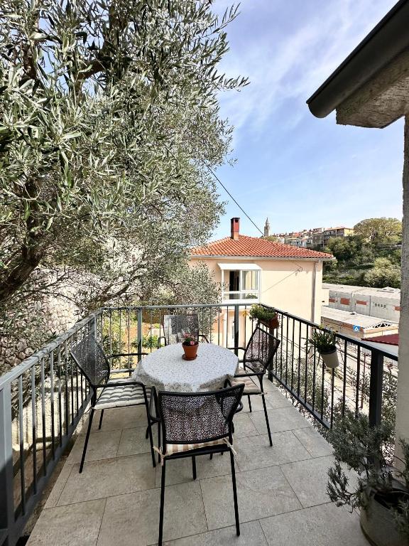 a patio with a table and chairs on a balcony at Apartment Grappa in Vrbnik