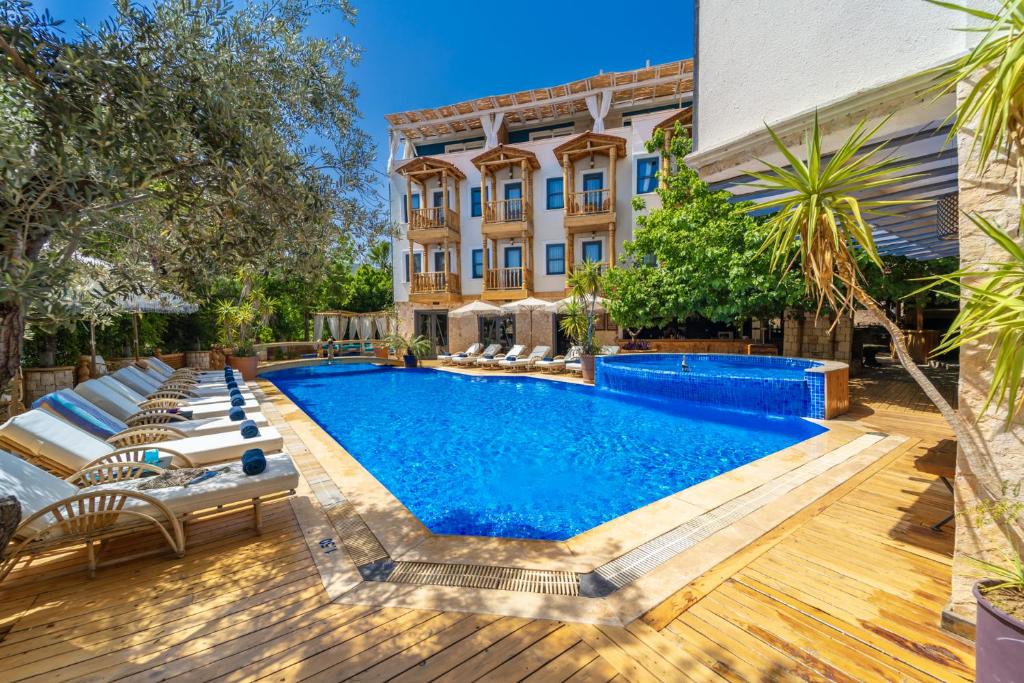 una piscina al aire libre con sillas y un edificio en Elixir Hotel, en Kalkan