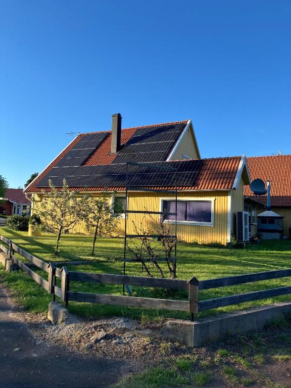 a yellow house with a fence in front of it at Kalmar - Bergavik in Kalmar