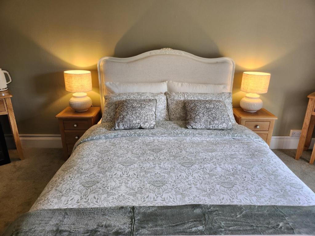 1 dormitorio con 1 cama grande y 2 lámparas en Hillarnias Tearoom and B&B en Shaftesbury