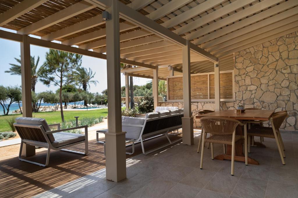 a patio with a table and chairs and a piano at Elya Beach Luxury Suites in Ayios Theodhoros