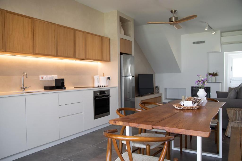 a kitchen and dining room with a wooden table at Elya Beach Luxury Suites in Ayios Theodhoros