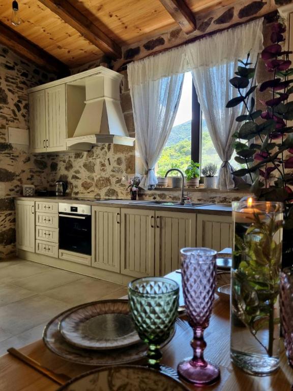 a kitchen with a table with a sink and a stove at Mesavlia Traditional Stone House in Mesávlia