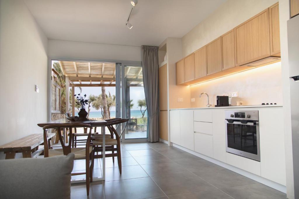 a kitchen with a table and a dining room at Elya Beach Luxury Suites in Ayios Theodhoros