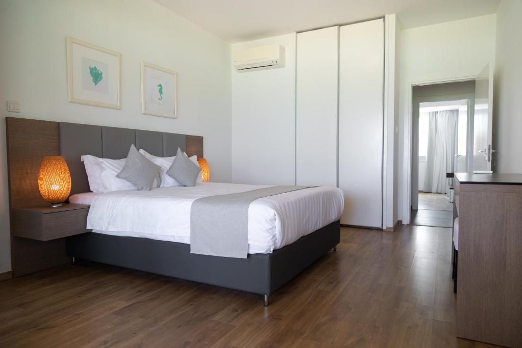 a bedroom with a large bed with white sheets at Elya Beach Luxury Suites in Ayios Theodhoros