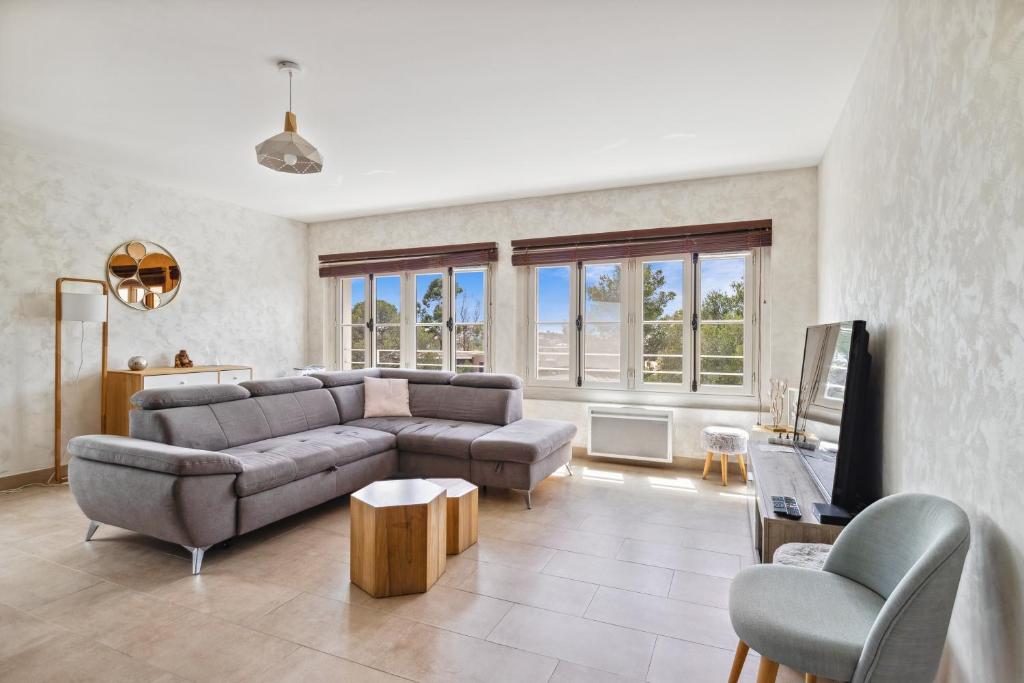 un salon avec un canapé et une chaise dans l'établissement Appartement de Messugues - Appt standing vue mer, à Saint-Raphaël