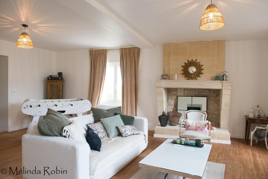 モンターニュにあるVilla aux portes de Saint Emilionの白いソファと暖炉のあるリビングルーム
