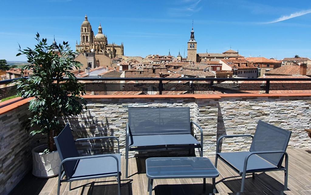 um grupo de cadeiras numa varanda com vista para a cidade em Real Segovia Apartments by Recordis Hotels na Segóvia