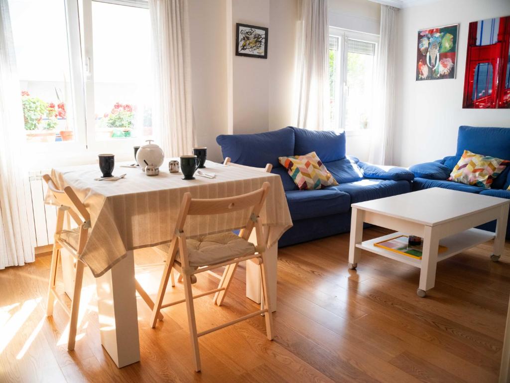 een woonkamer met een blauwe bank en een tafel bij Casilla's House en Indautxu in Bilbao