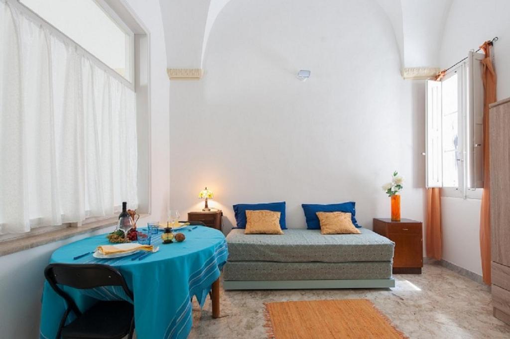 sala de estar con mesa azul y sofá en Casa La Ronza, en Lecce