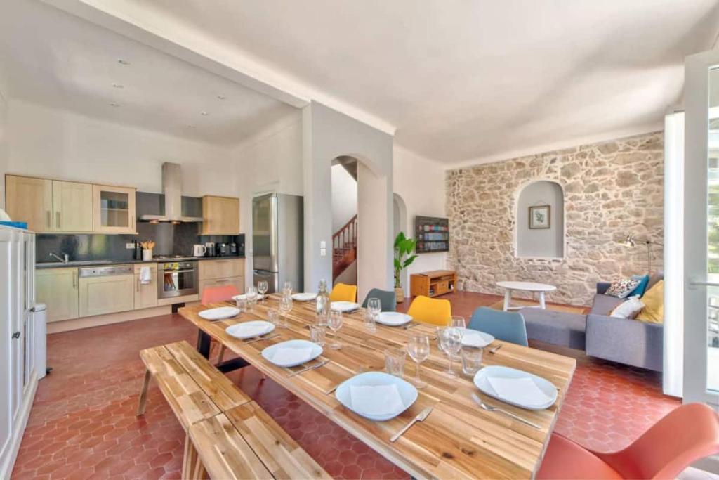 a dining room and living room with a wooden table at Maison Martel in Antibes