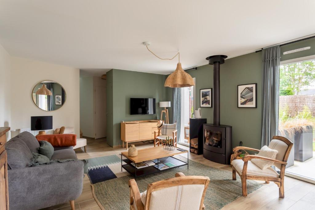 a living room with a couch and a table at La Cabane des Ebihens - A moins d'1km de la plage in Lancieux