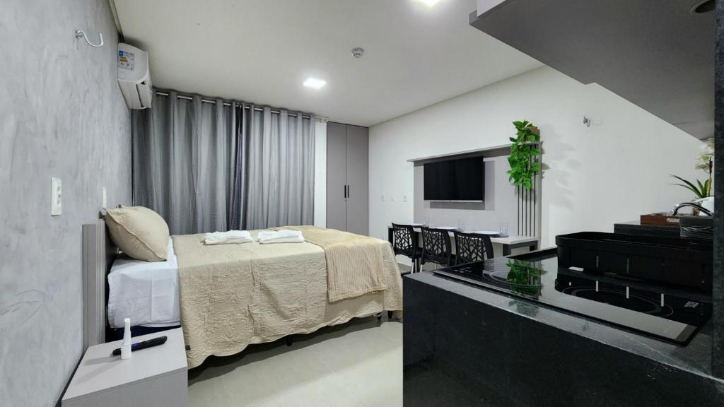 a hotel room with a bed and a television at Studio Flat Tramonto in João Pessoa