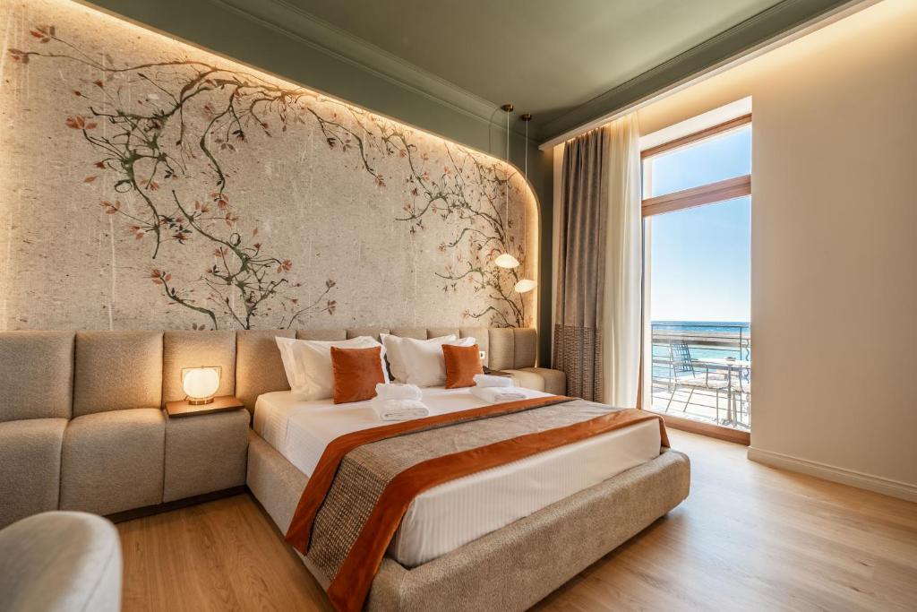 een slaapkamer met een bed, een bank en een raam bij MiraVita Boutique Hotel - Adults Only in Chania