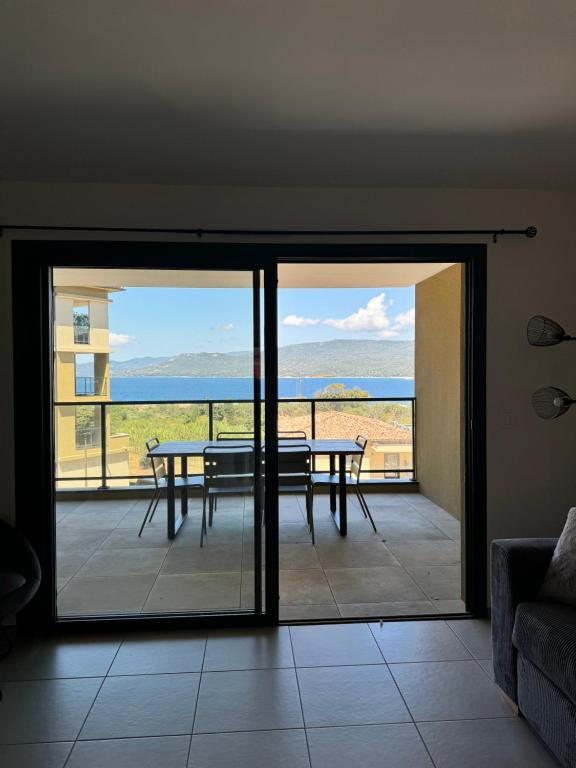 une chambre avec un balcon avec une table et une vue dans l'établissement T3 de standing neuf vue mer, à Propriano