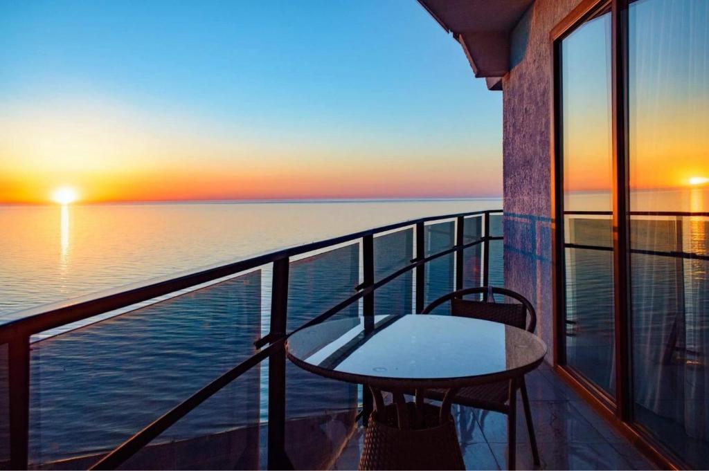 a balcony with a table and a view of the ocean at sea view rooms in Batumi in Batumi